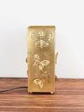 Go Hooked gold metal table lamp with butterfly cutouts and embossed butterfly on top. Off-white shade.