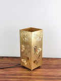 Go Hooked decorative square metal table lamp in gold with butterfly cutouts and an off-white shade. Touch switch.