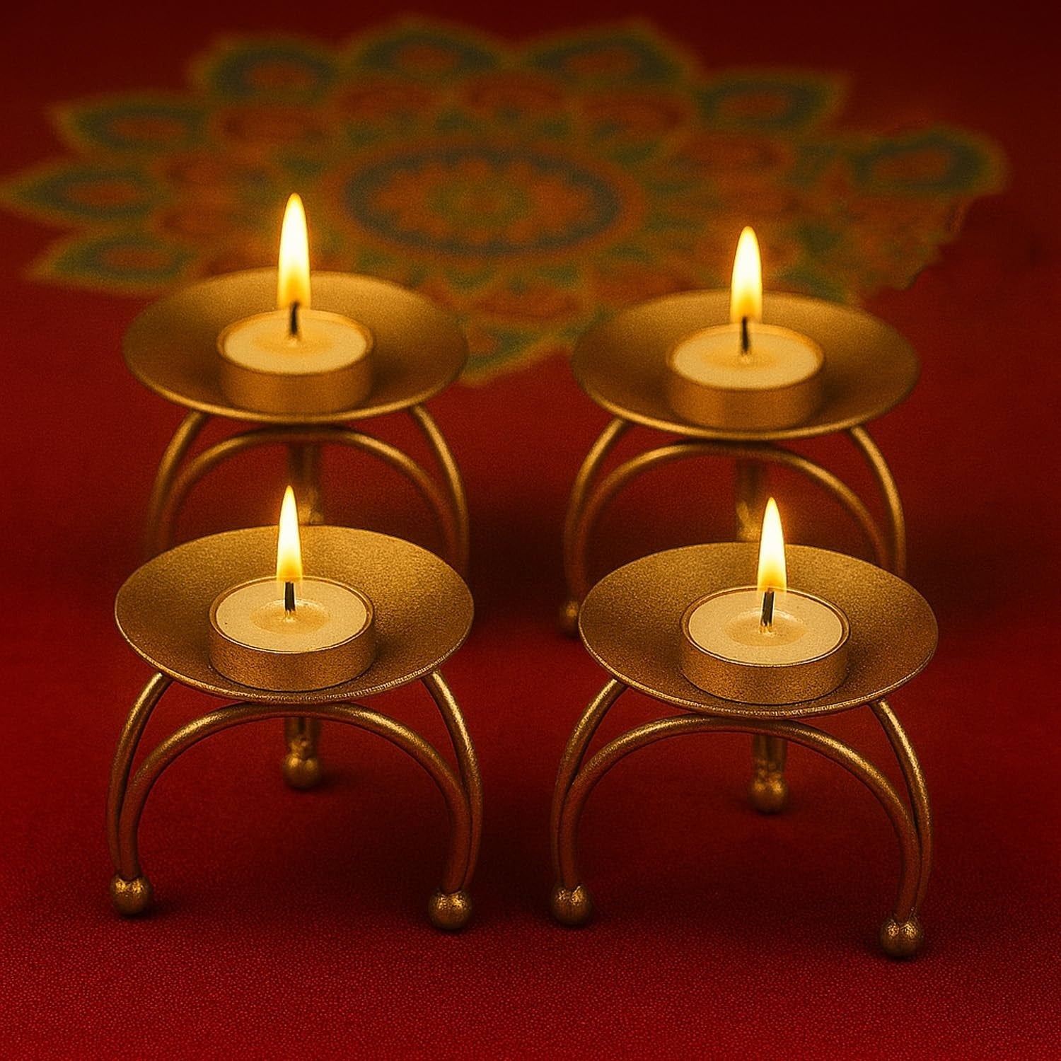 Go Hooked set of 4 matte gold metal pedestal tealight candle holders with burning candles.