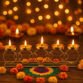 GoHooked gold metal tealight candle holder with 5 trays in a circular ring design, adorned with marigolds and rangoli.