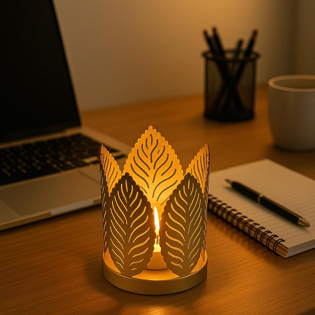 GoHooked matte gold metal crown tealight holder with leaf cut design, casting warm light.