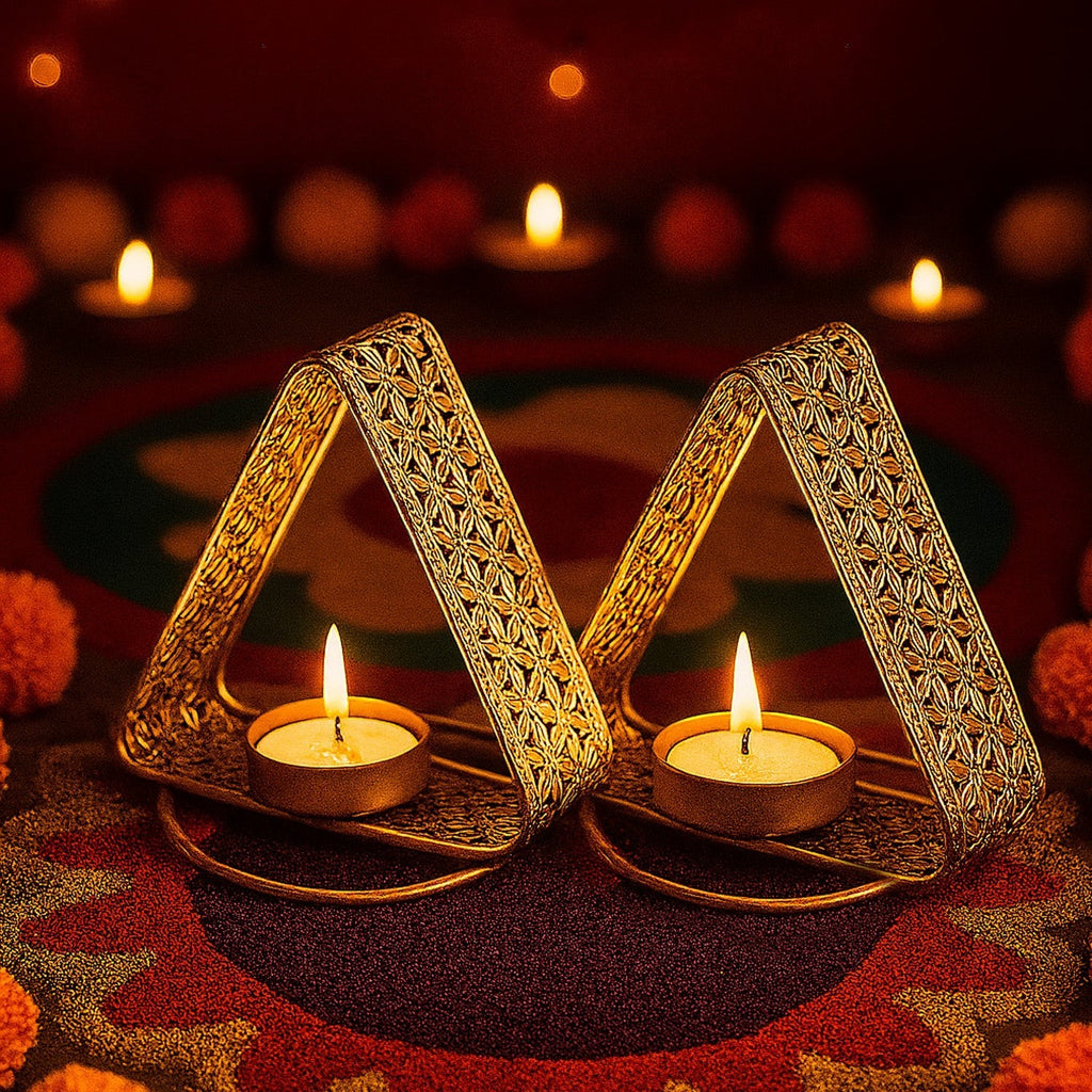 GoHooked set of 2 gold metal triangular tealight holders with floral cutwork design, casting warm light.
