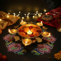 Go Hooked gold metal decorative urli bowl with 5 tealight holders, filled with water, marigolds, and rose petals.