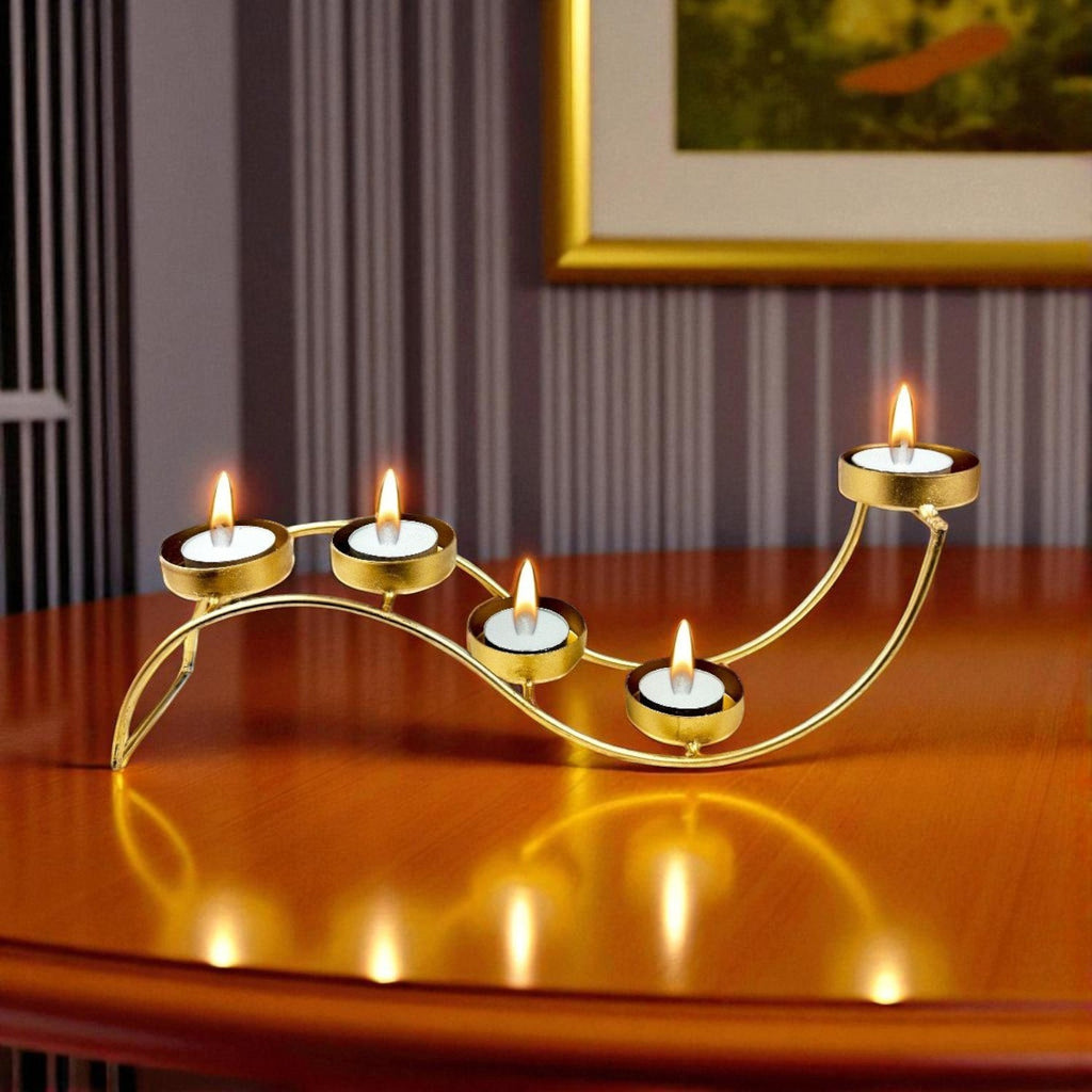 Go Hooked gold metal wave tealight candle holder with 5 trays on a wooden table.