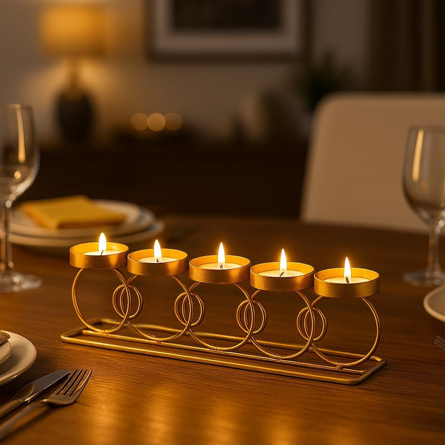 GoHooked RingLine tealight holder in matte gold finish with 5 lit candles on a wooden table.
