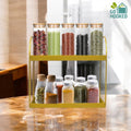 GoHooked golden 2-tier metal standing rack with glass jars of spices and dried herbs on a marble countertop.