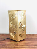 Go Hooked decorative golden metal table lamp with butterfly cutouts and off-white shade. Touch switch.