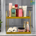 GoHooked golden metal 2-tier standing rack holding cosmetics, towels, and skincare products.