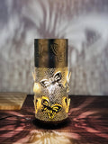 Go Hooked golden metal bedside table lamp with intricate butterfly cutouts, casting decorative shadows.