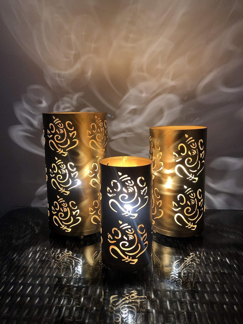 Go Hooked set of 3 golden metal table lamps with intricate Ganesha cutouts, casting decorative shadows.