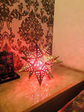Go Hooked golden metal star-shaped table lamp with cut-out stars, casting a warm glow. Ideal for bedrooms and romantic settings.