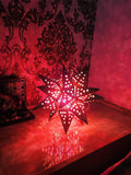 Go Hooked golden metal star-shaped table lamp with cut-out stars, casting a warm glow. Ideal for romantic decor.
