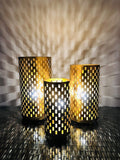 GoHooked set of 3 golden metal table lamps with cutout patterns casting decorative shadows. Art Deco style.
