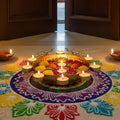 GoHooked golden peacock urli bowl with 8 tealight holders, filled with water, flowers, and petals. Festive decor.
