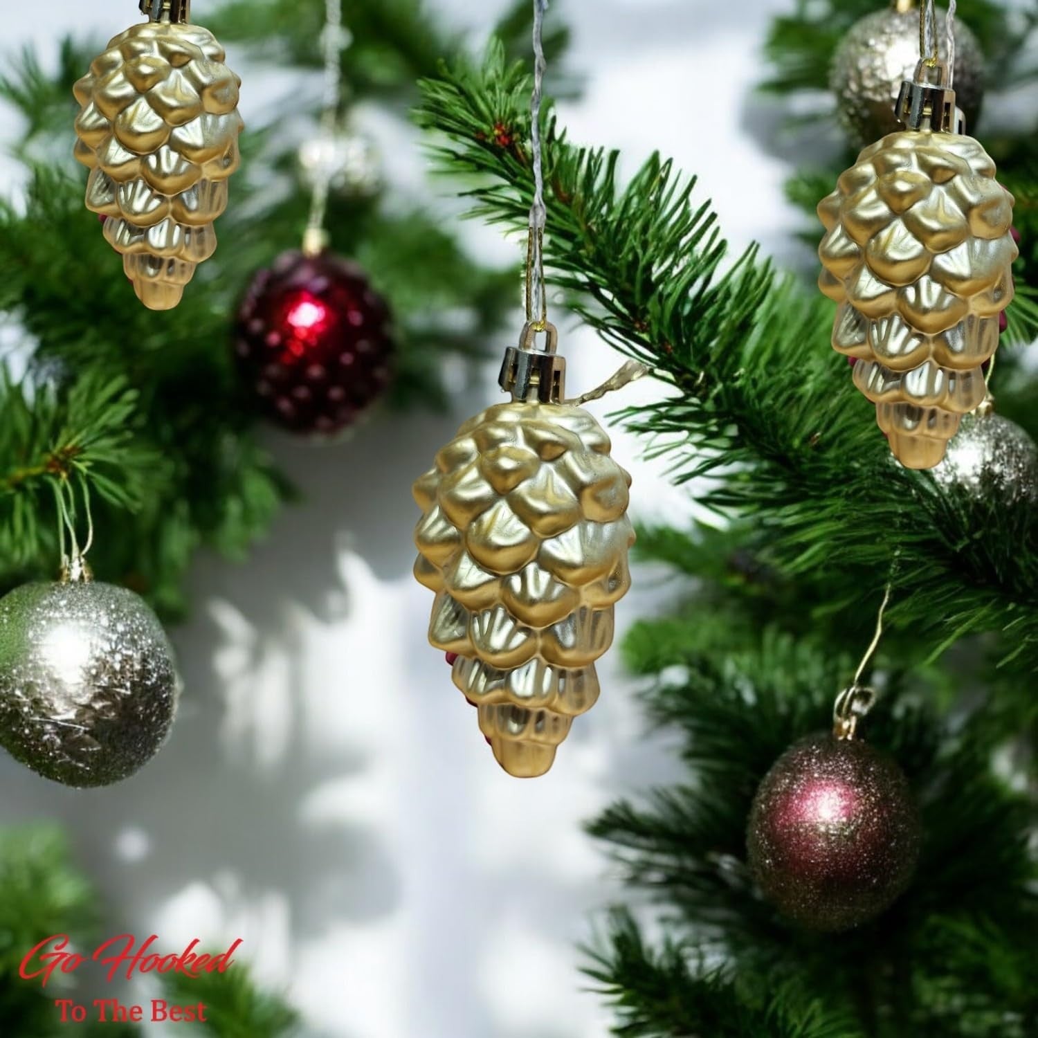 GoHooked golden pine cone Christmas ornaments with glitter accents, pack of 6, hanging on a decorated tree.