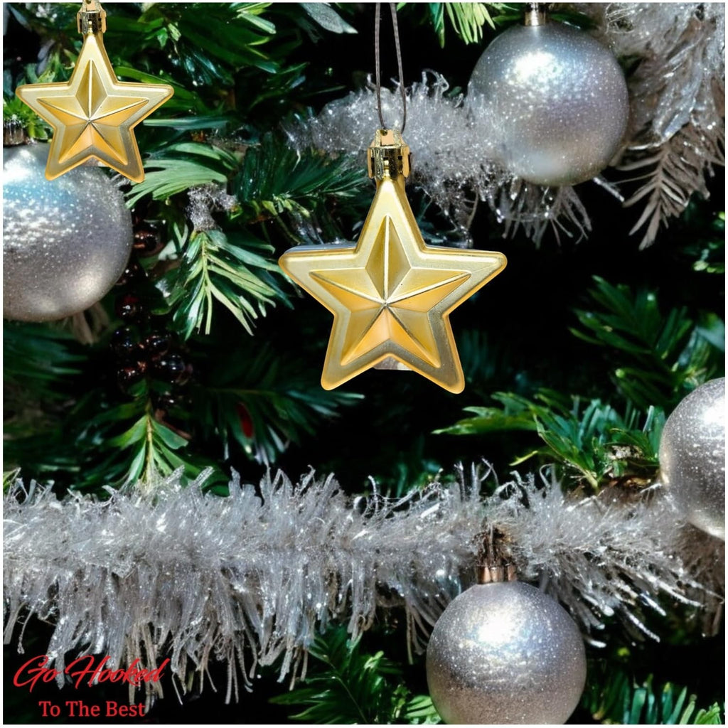 GoHooked golden star Christmas ornaments with glitter accents, hanging on a decorated tree with silver baubles.