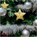 GoHooked golden star Christmas ornaments with glitter accents, hanging on a decorated tree with silver baubles.