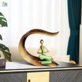 Go Hooked green polyresin meditating woman statue in yoga pose on a gold leaf-shaped base.