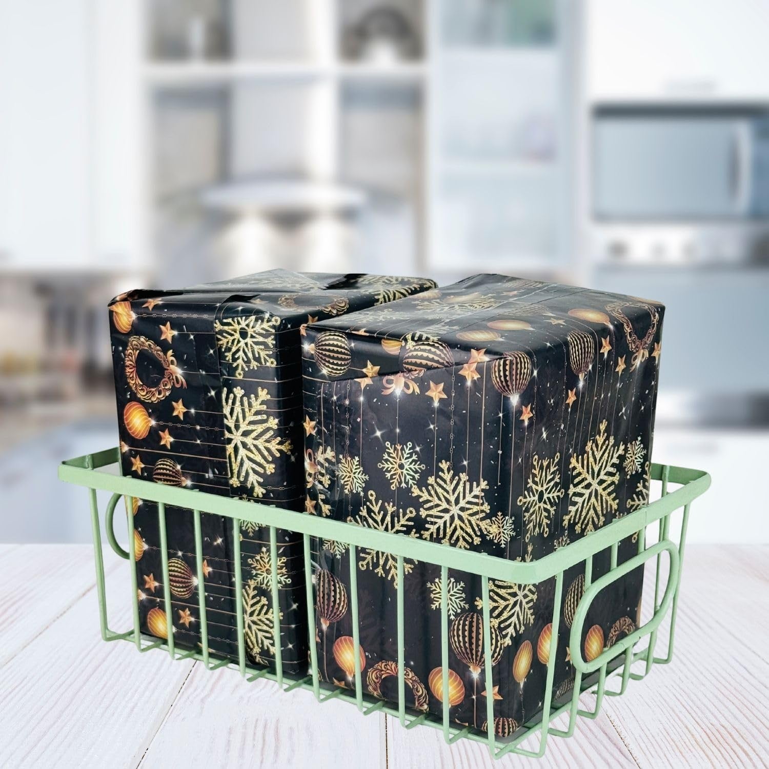 GoHooked green metal wire grid basket holding two black gift-wrapped packages with gold snowflakes and ornaments.