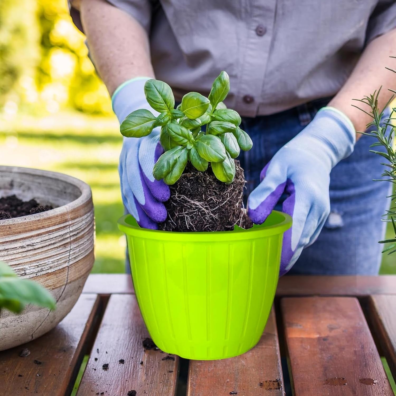 GoHooked green plastic planter pot with ribbed texture, 8 inch, for indoor/outdoor gardening. A person wearing gardening gloves plants a basil seedling.