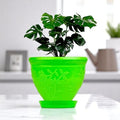 Go Hooked green plastic planter pot with embossed floral design and matching saucer, holding a monstera plant.