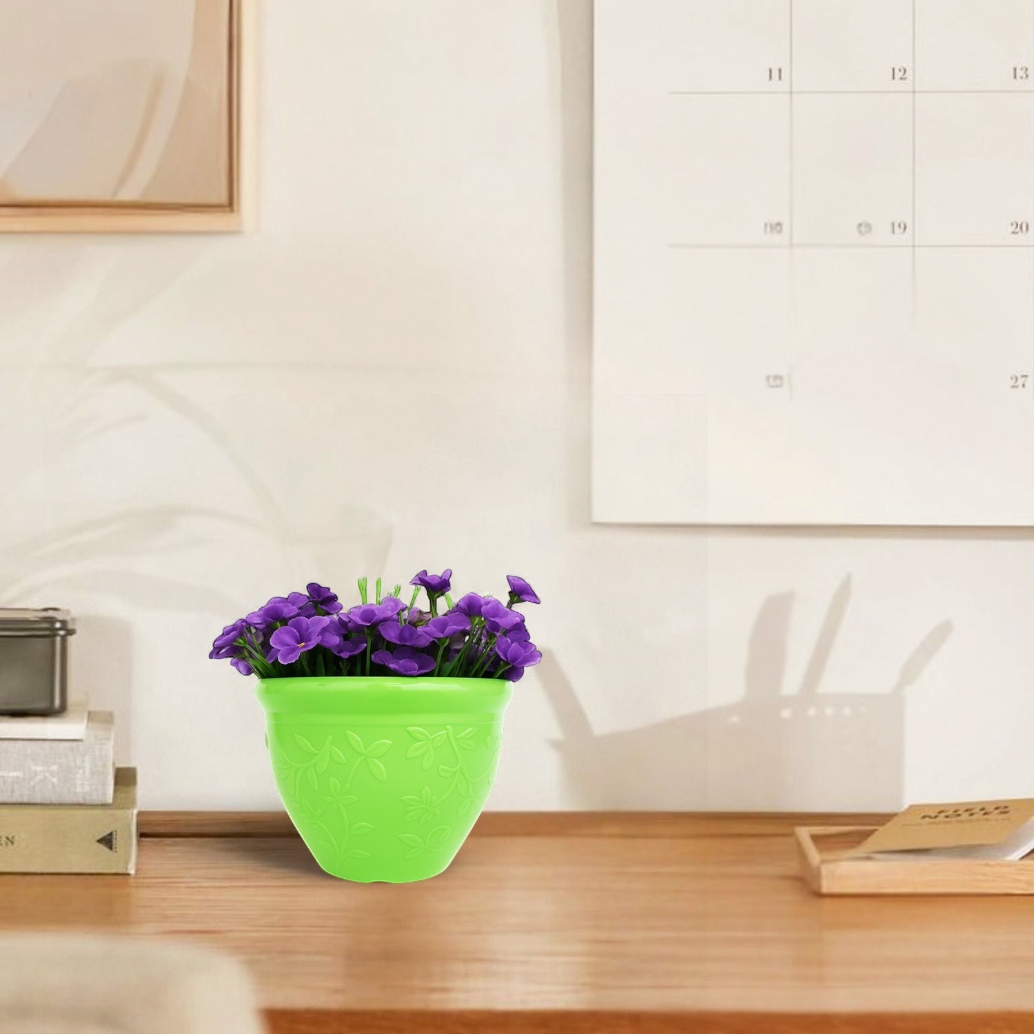 GoHooked bright green plastic Victory planter pot with purple flowers on a wooden desk in a modern home office