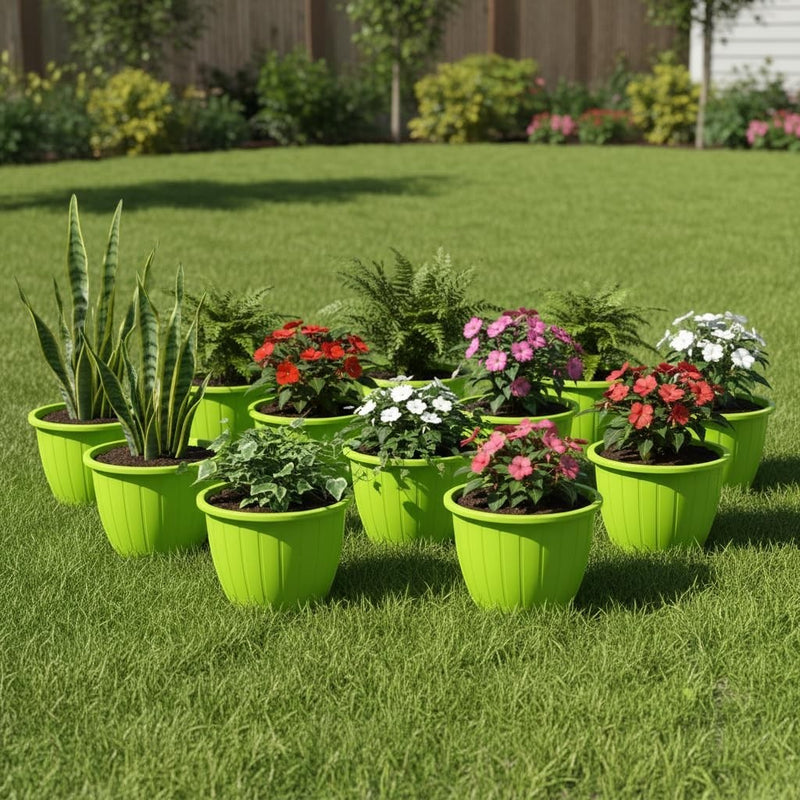 Go Hooked 10-inch green plastic planters with fluted design, holding various flowering plants and snake plants on a lawn.