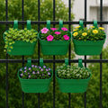 GoHooked green plastic railing hanging planter set of 5, rectangular pots with double hooks holding flowers and plants on a black fence.