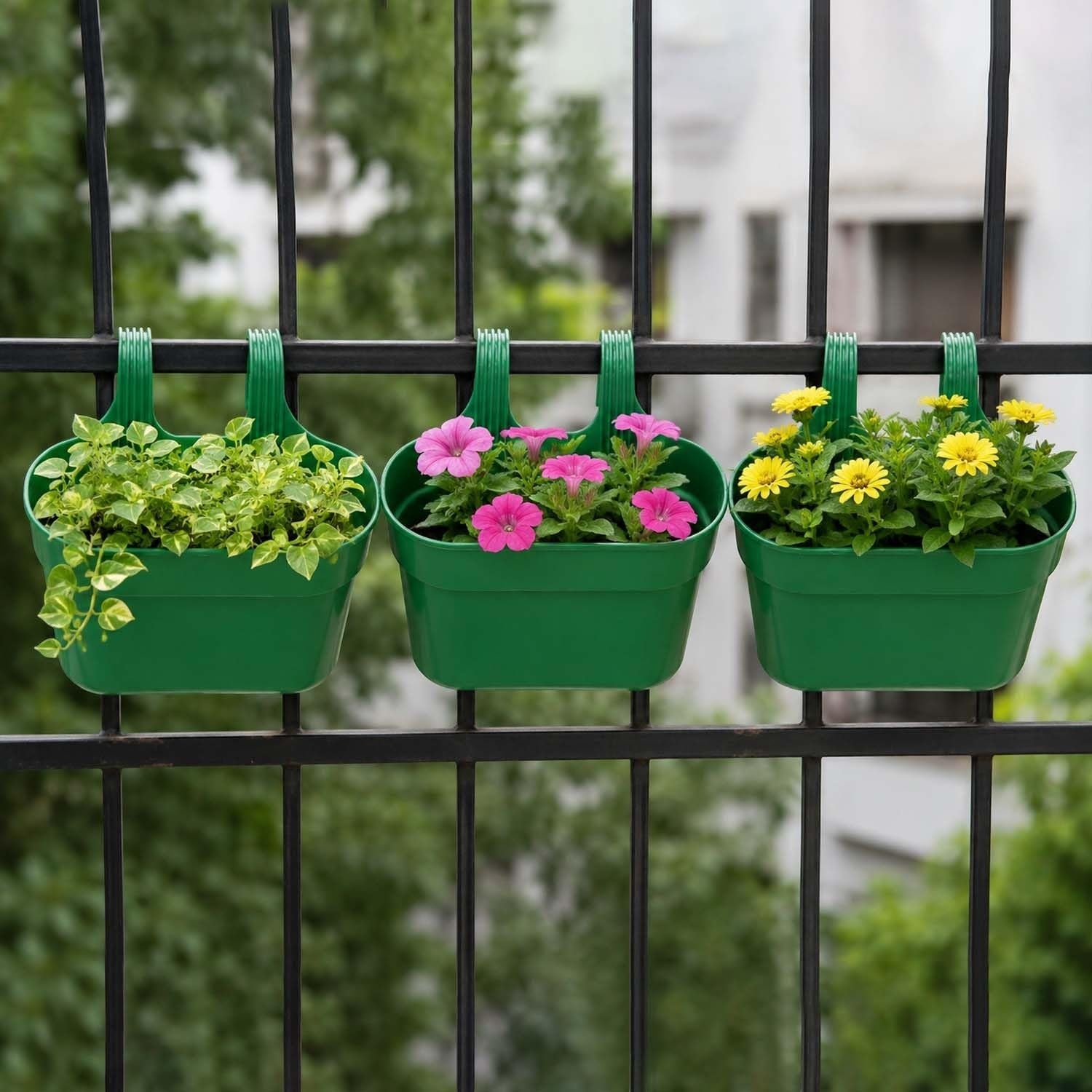 GoHooked set of 3 green plastic railing hanging planters with double hooks, holding green foliage, pink petunias, and yellow daisies.