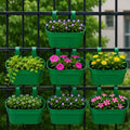 GoHooked set of 7 green plastic railing hanging planters with double hooks, holding various flowers and plants.