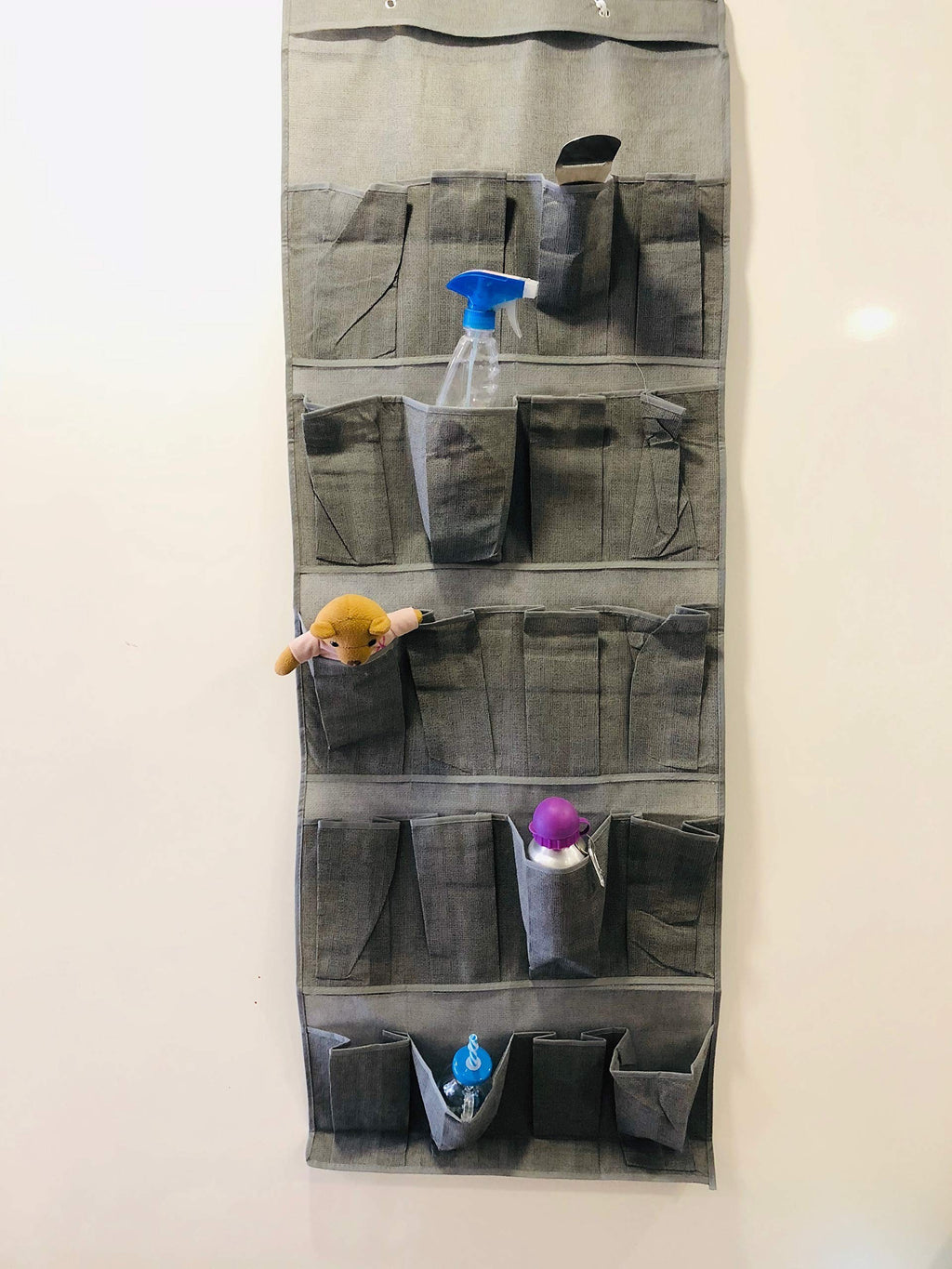 GoHooked grey non-woven fabric 20-pocket door organizer with clear pockets holding various items like spray bottle, toys, and bottles.