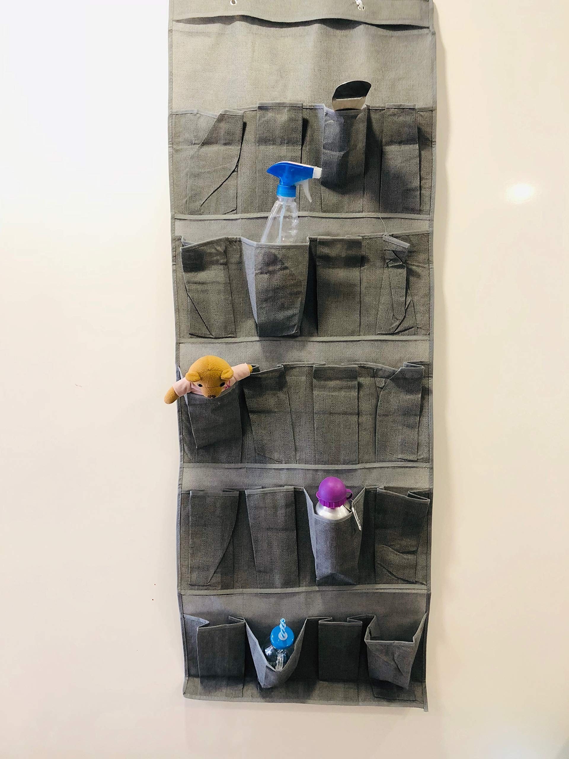GoHooked grey non-woven fabric 20-pocket door organizer with clear pockets holding various items like spray bottle, toys, and bottles.