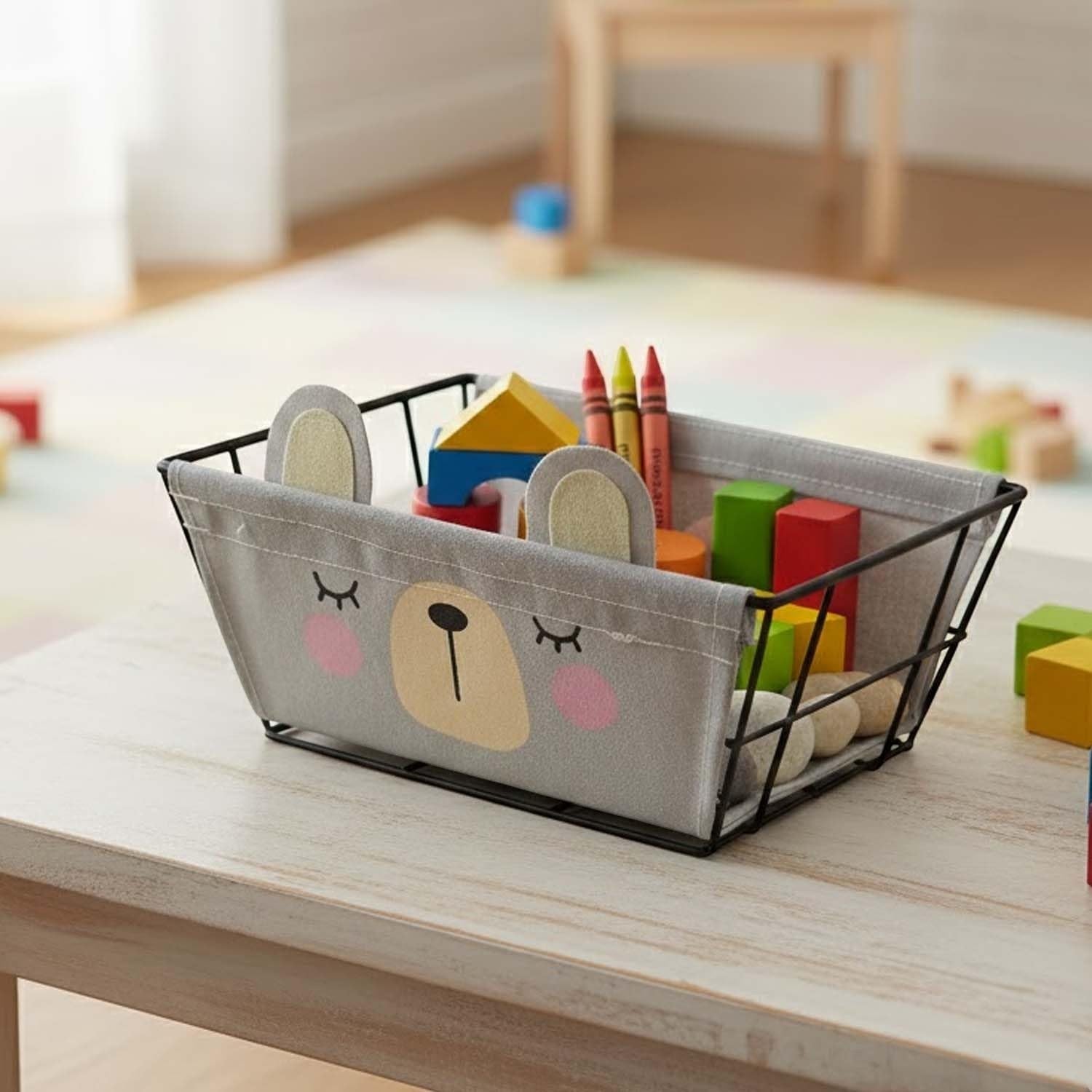 Go Hooked grey metal wire storage basket with cute bear face design and detachable fabric liner, filled with children's toys.