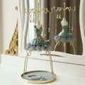 GoHooked grey doll dress jewelry holder stand with metal hooks and a velvet-lined base tray on a vanity table