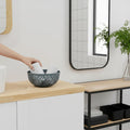 GoHooked light grey plastic basket with a decorative geometric pattern, holding white towels.