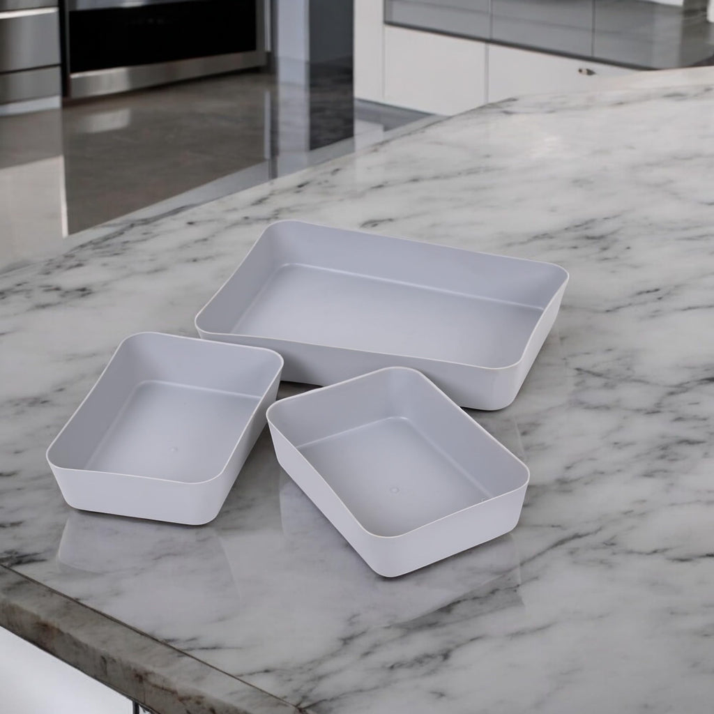 Go Hooked set of 3 grey plastic storage trays on a marble countertop. Versatile organizers for kitchen, office, makeup, and stationery.