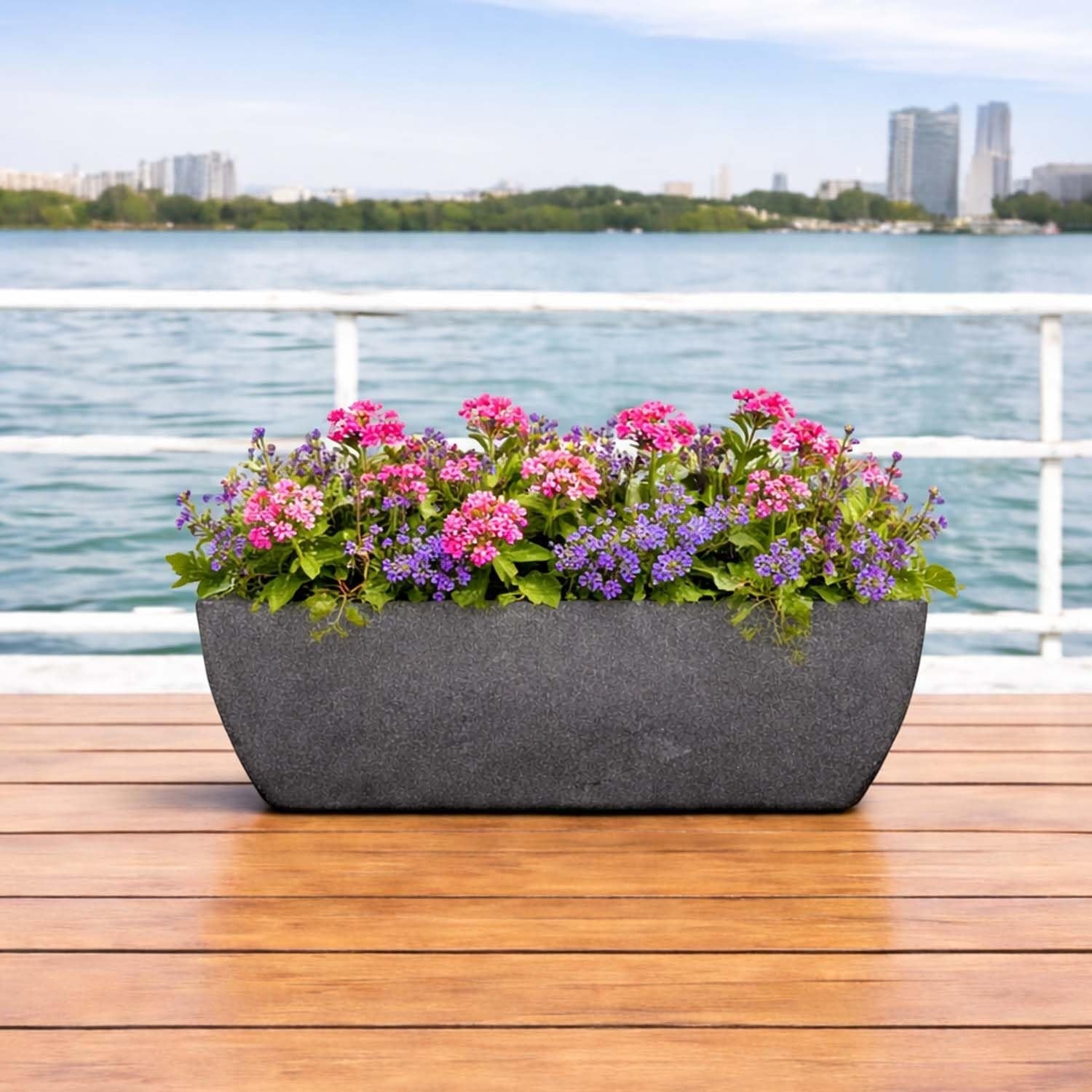 GoHooked grey rectangular polymer planter with ribbed design, filled with pink and purple flowers, on a wooden deck.