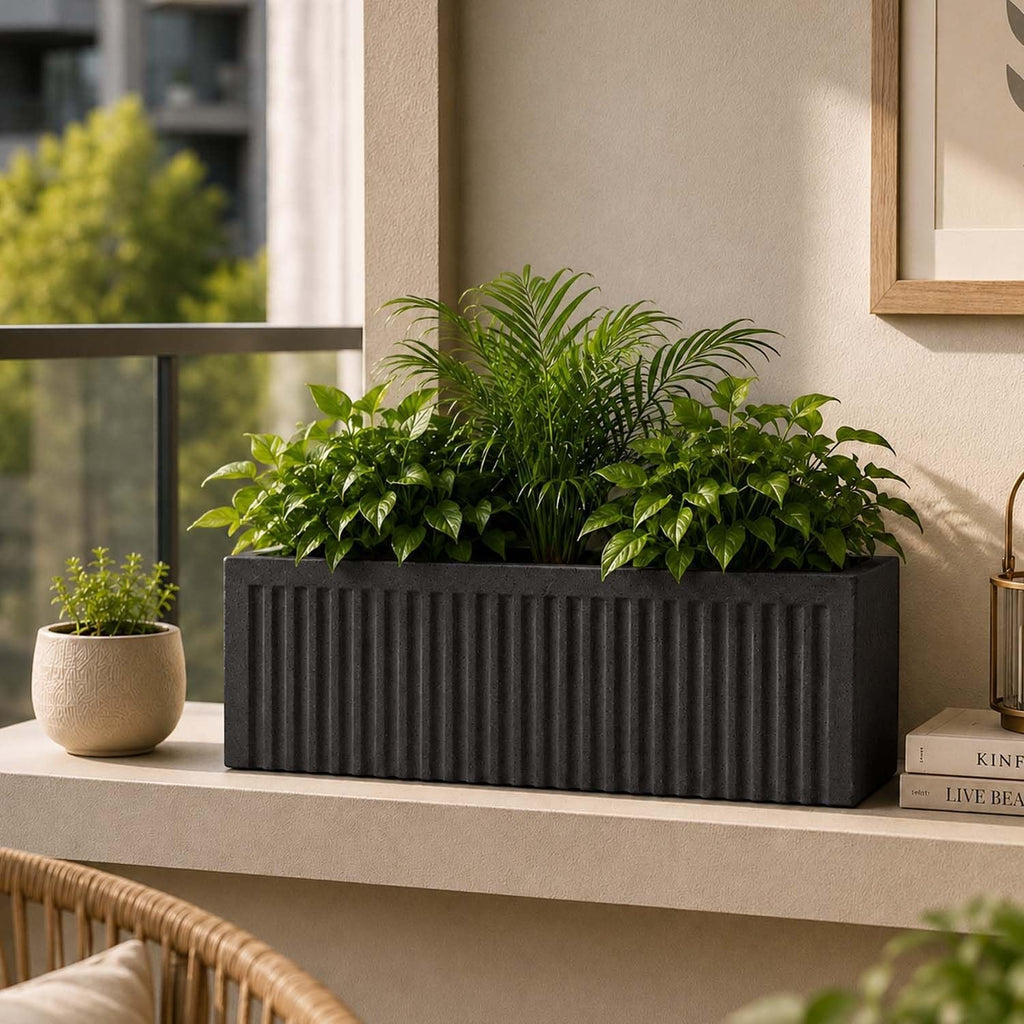 GoHooked dark grey ribbed rectangular polymer planter pot filled with lush green plants on a balcony.