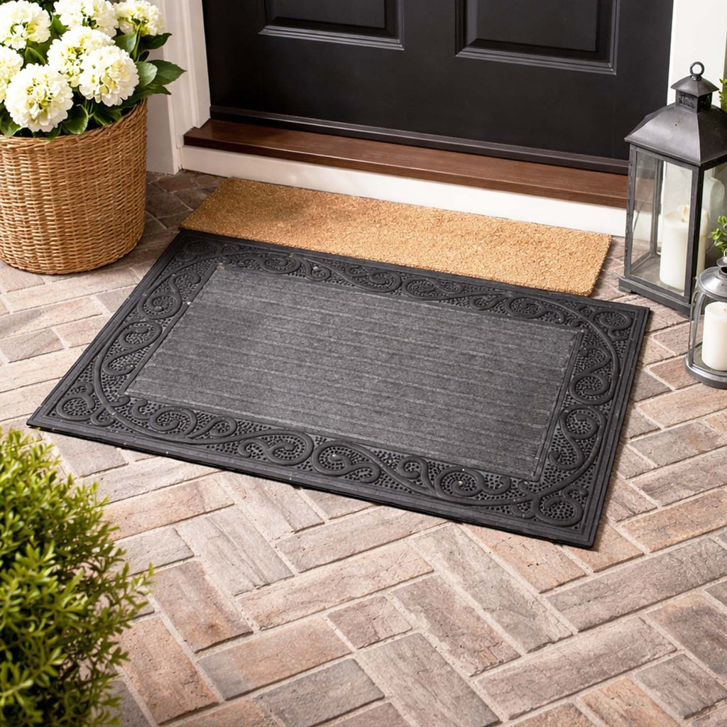 GoHooked grey rubber door mat with a decorative border and ribbed surface on a brick patio entrance.