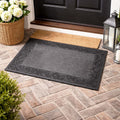 GoHooked grey rubber door mat with a decorative border and ribbed surface on a brick patio entrance.