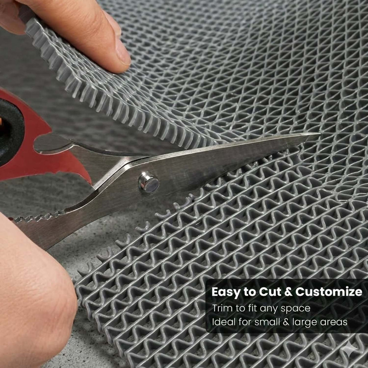 GoHooked grey anti-skid rubber bathroom mat being trimmed with scissors for a custom fit in wet areas.