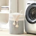 GoHooked cotton rope laundry basket in grey and white with sturdy handles, placed in a modern laundry room.