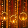 GoHooked set of 3 matte gold metal hanging tealight candle holders with floral cut design and chains.