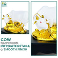 GoHooked white polyresin Kamdhenu cow and calf statue with gold accents and red eyes, symbolizing prosperity.
