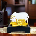 Go Hooked white polyresin Kamdhenu cow and calf statue with gold accents and red eyes on a black base.