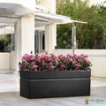 Go Hooked large black rectangular polymer planter pot with modern design and drainage hole, filled with pink flowers.