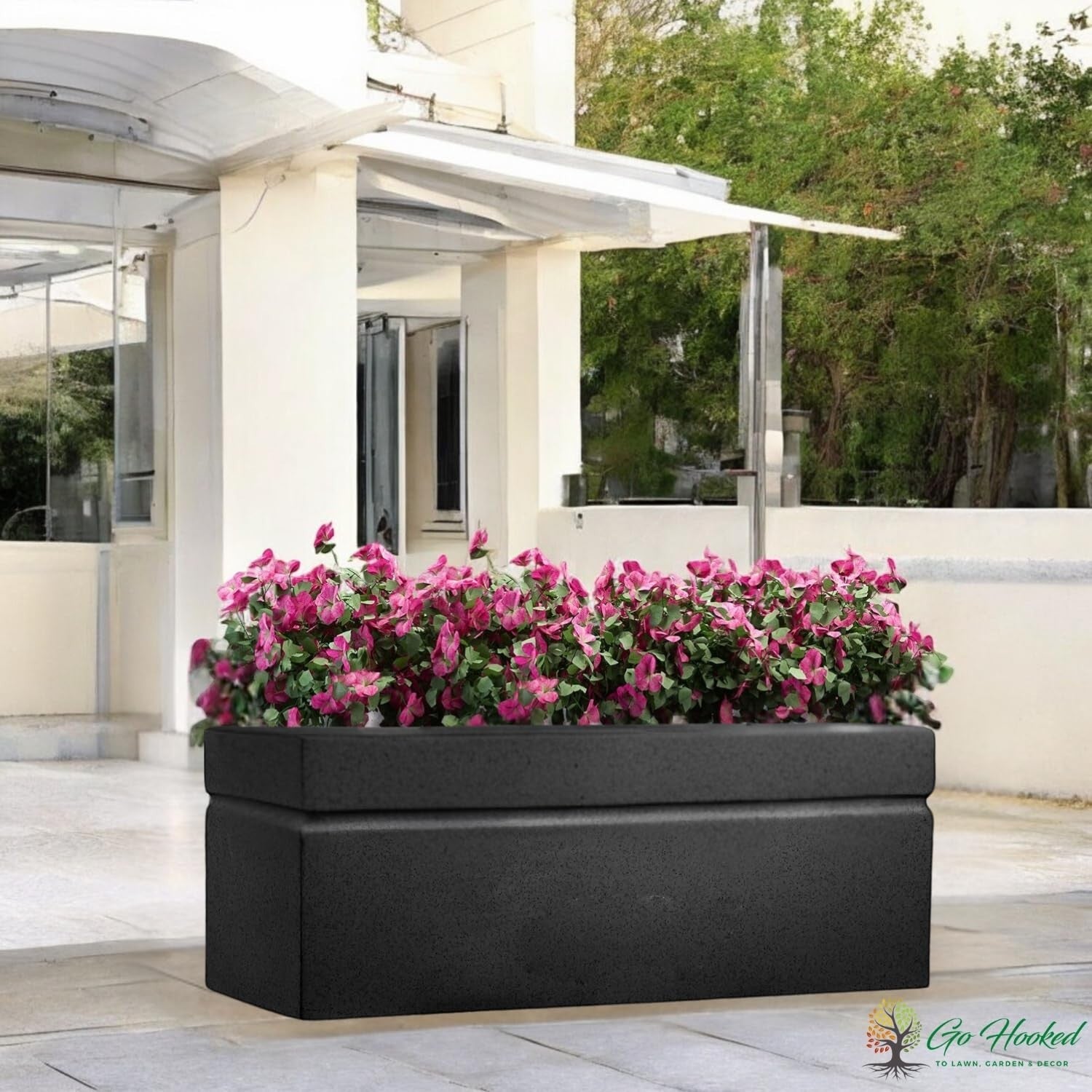 Go Hooked large black rectangular polymer planter pot with modern design and drainage hole, filled with pink flowers.