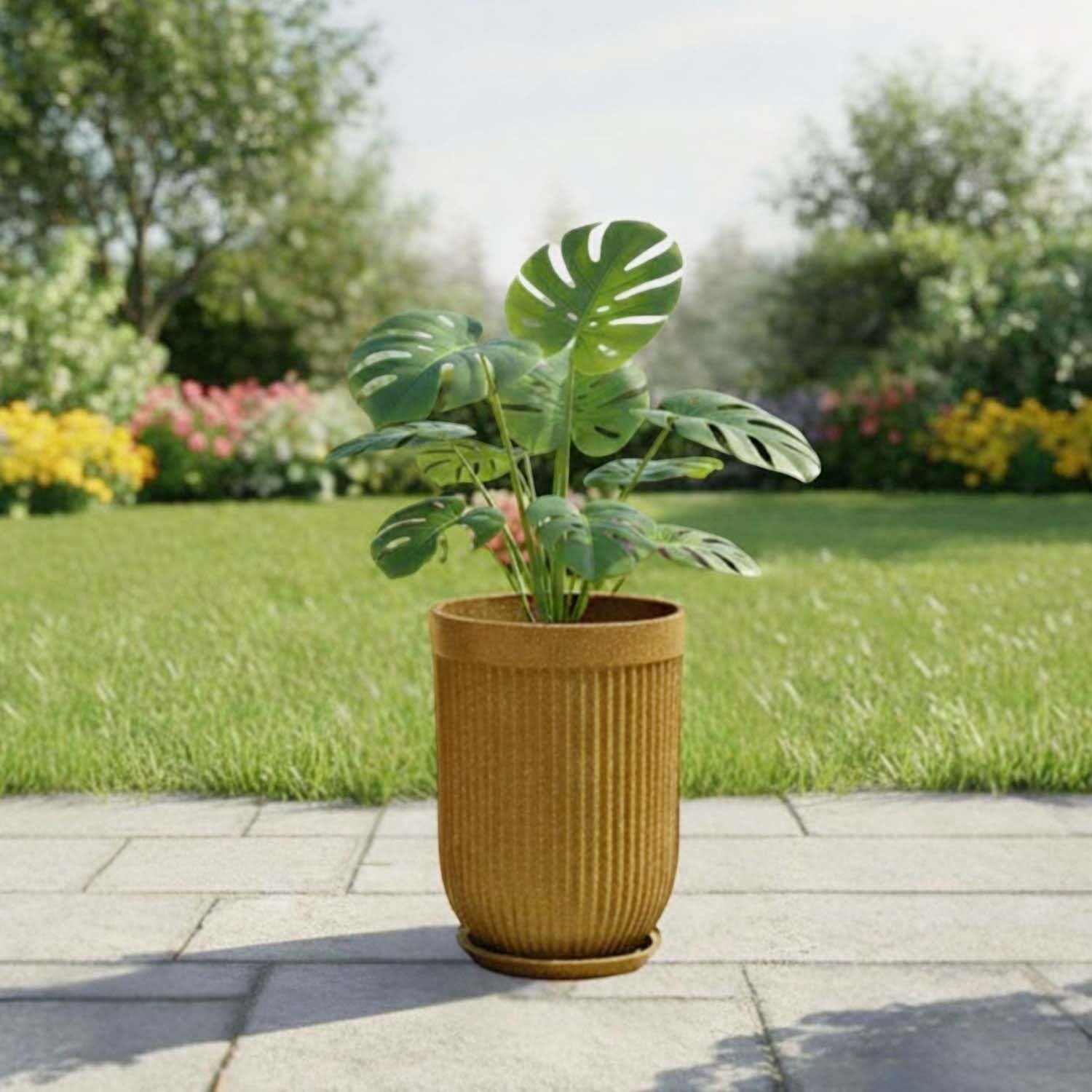 GoHooked 18-inch large ribbed polymer planter in mustard yellow with a matching saucer tray, holding a Monstera plant on a paved patio.