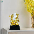 GoHooked white and gold polyresin laughing Buddha statue symbolizing prosperity and happiness, on a black base.