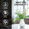 Go Hooked lavender baby's breath artificial flowers in a white geometric vase with green fern leaves. Realistic faux plant decor.